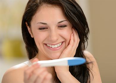 Smiling girl looking at a pregnancy test
