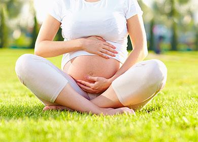 Mujer embarazada sentada en el césped