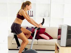 Training on a stationary bike at home in front of the TV