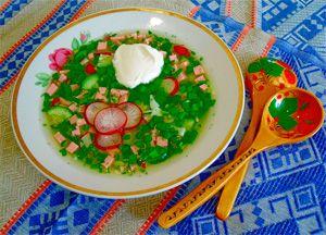 On a blue tablecloth is a plate with okroshka on mineral water