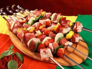 Brochettes crues sur des brochettes sur une planche de bois