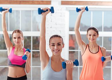 Girls do exercises with dumbbells.