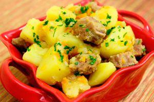 Agneau aux pommes de terre dans une assiette rouge