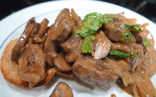 Beef stroganoff on a plate with greens