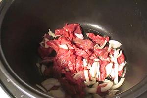 Chopped beef and onion in a multicooker bowl