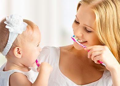 Mom and daughter brush their teeth