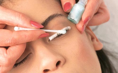 Makeup artist gently applying glue to eyelashes