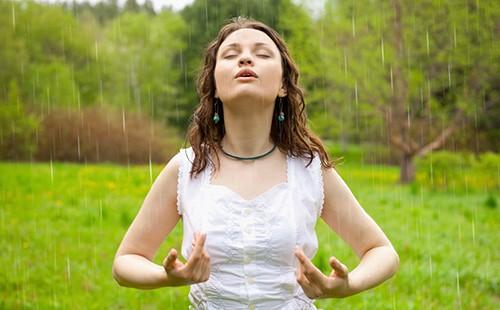 A girl in a white blouse revels in the clean forest air