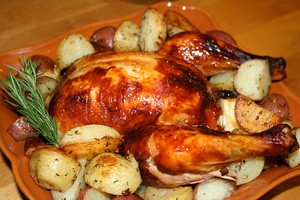 Baked chicken with potatoes on a wooden board