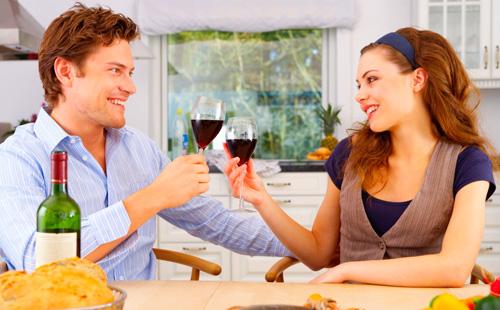 Marido y mujer cenando con copas de vino