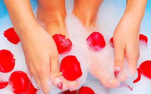 Feet in soap foam with rose petals