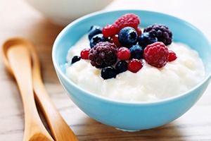 Gachas de leche con bayas silvestres en un tazón azul