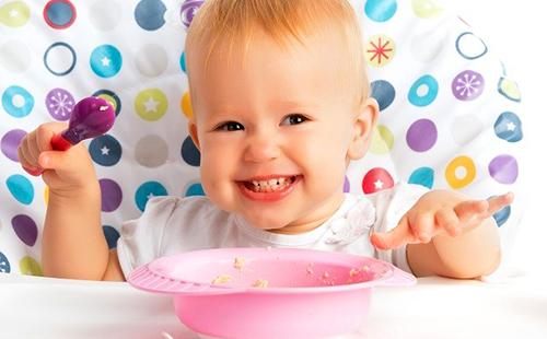 Girl loves porridge in a pink plate