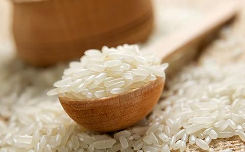 Granos de arroz en una cuchara de madera