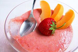 Pink porridge with fruits in a glass bowl