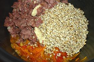 Vegetables, meat and cereals are laid out in layers in the multicooker bowl