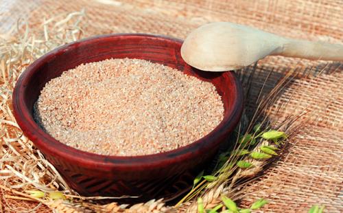 Cereal triturado en un recipiente enmarcado por espiguillas