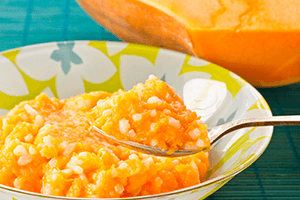 Bright orange watermelon porridge with rice in a colorful plate