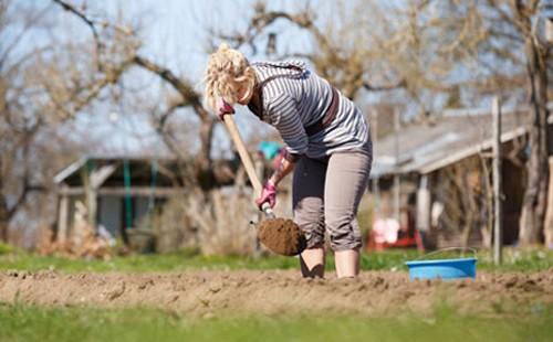 Woman dripping a shovel in the garden