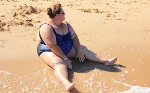 Bbw sjedi na pijesku na plaži