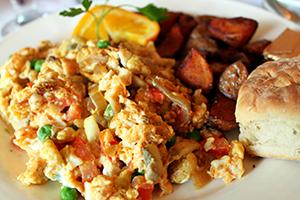 Huevos fritos con verduras, guisantes y pan recién horneado.