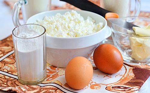 Cottage cheese in a plate, eggs and flour in a glass