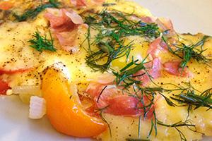 Huevos fritos con tocino y tomates.