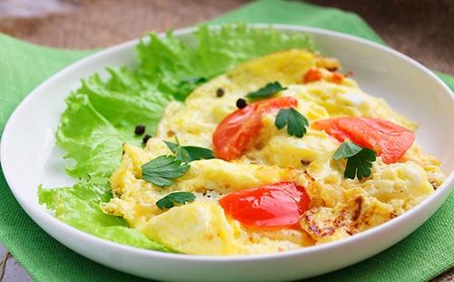 Omelet with tomatoes, cheese and herbs on a plate