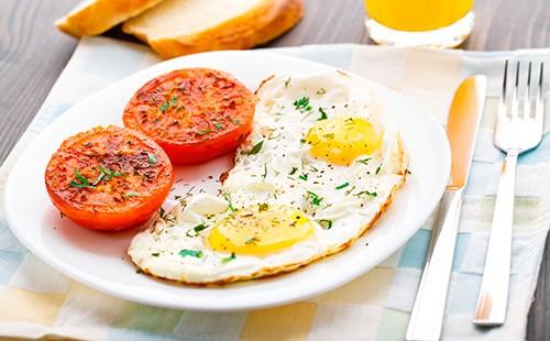 Huevos fritos con tomate en un plato