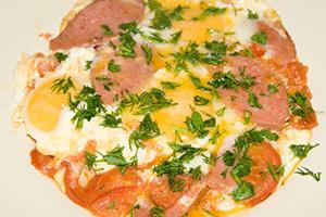 Fried eggs with sausage and tomatoes