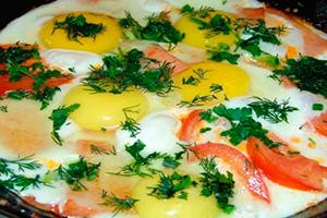 Fried eggs with tomatoes, onions and herbs