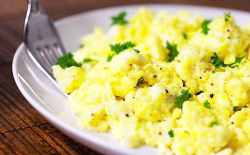 Œufs brouillés sur une assiette blanche