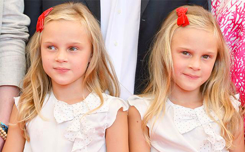 Fair-haired twin girls with red bows