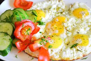 Fried eggs with cucumbers and tomatoes