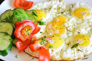 Œufs sur le plat avec des concombres et des tomates