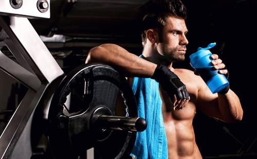 Brutal man near the barbell in the gym