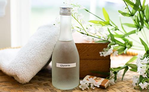 White flowers, a soft towel and a bottle of glycerin