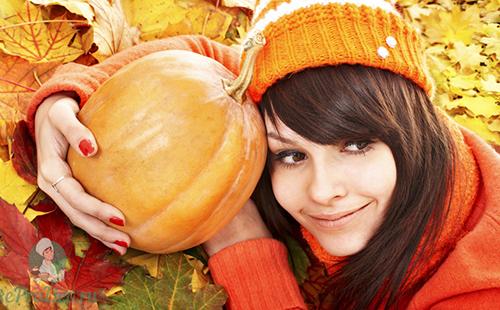 Chica con una gorra naranja abraza los frutos del otoño