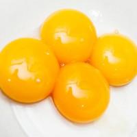 Four prepared yolks on a white plate
