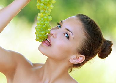 Girl holds grono of grapes