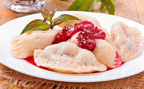 Dumplings with cherries on a white plate