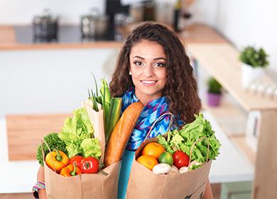 Young woman holds packages with vegetables in her hands