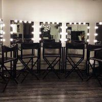 Osvjetljena ogledala na stolovima uz zid