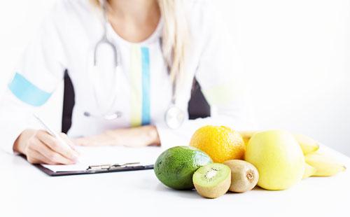 Doctor y frutas sobre la mesa