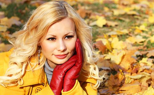 The blonde in red gloves among the autumn foliage