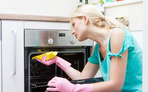 Woman rubs the oven