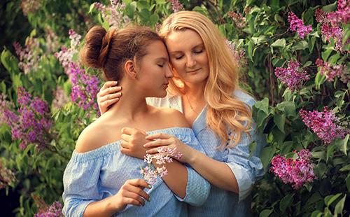 Anna and Vasilisa on the background of lilac flowers