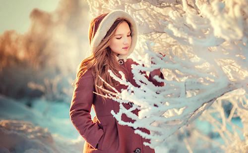 Mlada djevojka divi se smrznutim granama