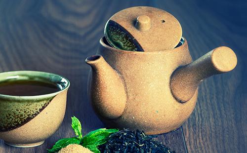 Black tea with mint and brown sugar in a ceramic set