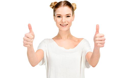 Joyful girl in a white T-shirt shows thumbs up